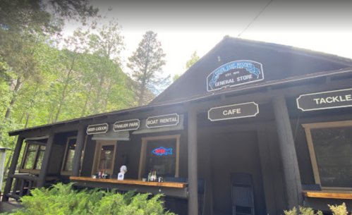 A rustic general store with a cafe, tackle shop, and boat rental, surrounded by trees in a scenic outdoor setting.