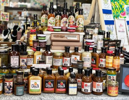 A colorful display of various sauces, jams, and condiments arranged on a table in a store.