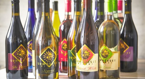 A collection of wine bottles from Summerset Winery, featuring various labels and colors arranged on a table.