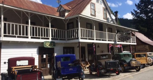 The exterior of a historic hotel in Northern California with several historic automobiles parked out front.