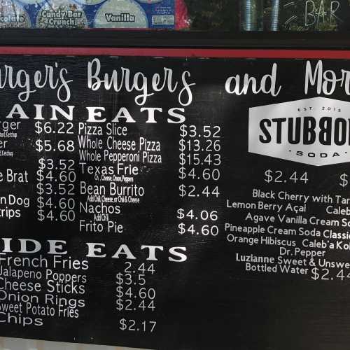 Menu board featuring burger and pizza options with prices, including fries and drinks.