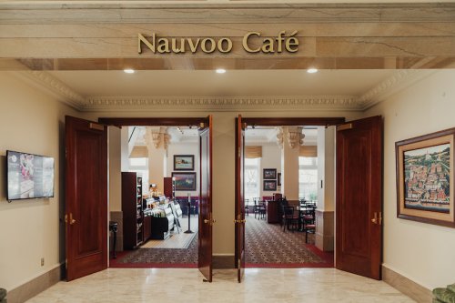 Entrance to Nauvoo Café with open double doors, showcasing a cozy dining area and decor.