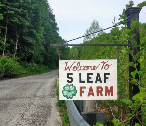 A wooden sign reading "Welcome to 5 Leaf Farm" hangs by a tree-lined road, with a green four-leaf clover graphic.