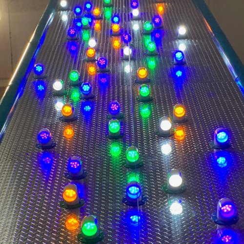 A metallic surface with colorful LED lights in various colors, creating a vibrant and dynamic pattern.
