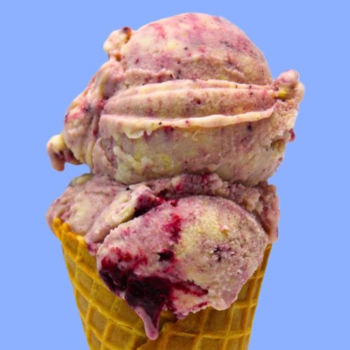 A close-up of a waffle cone filled with swirled berry ice cream against a light blue background.