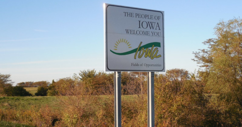 Welcome sign for Iowa, featuring the text "The People of Iowa Welcome You" and "Fields of Opportunities."