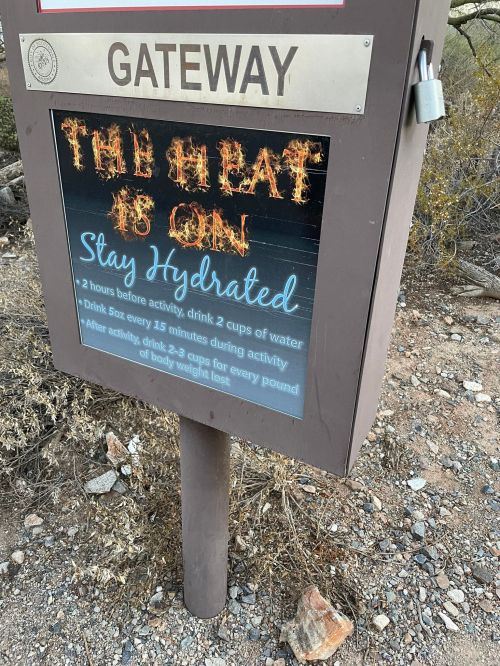 Sign at a trailhead reminding hikers to stay hydrated and drink water before, during, and after activities.