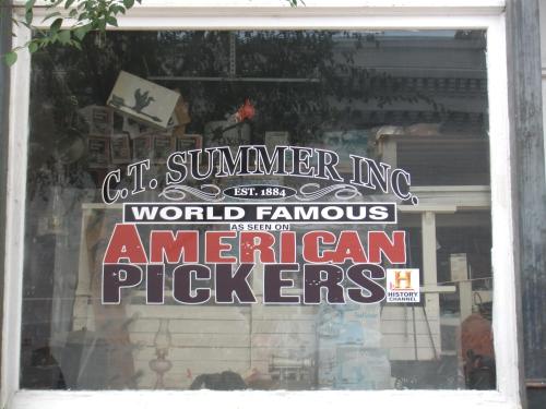 Sign in a window reading "C.T. Summer Inc. World Famous as seen on American Pickers, Est. 1884."