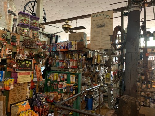 A cluttered vintage store filled with various tools, hardware, and nostalgic items, showcasing a unique charm.