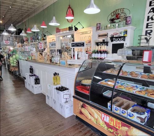 A cozy bakery interior featuring a display case with pastries, a coffee counter, and rustic decor.