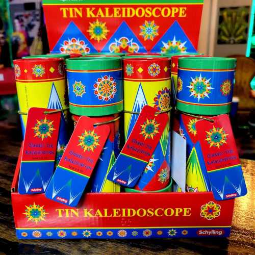 Colorful tin kaleidoscopes displayed in a vibrant box, each with a tag showcasing their design.