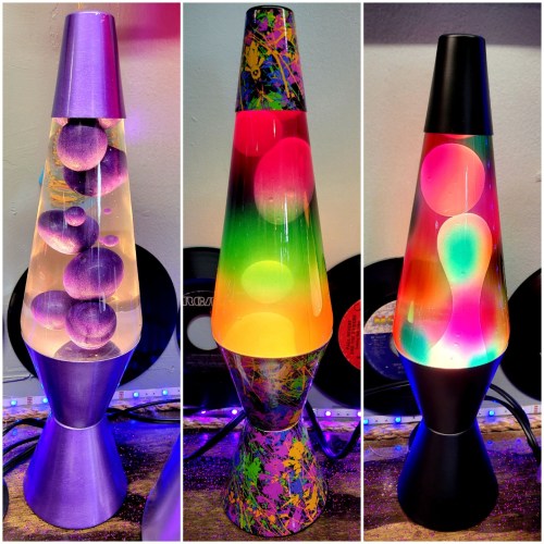 Three colorful lava lamps with different designs and vibrant, swirling colors, set against a backdrop of records.