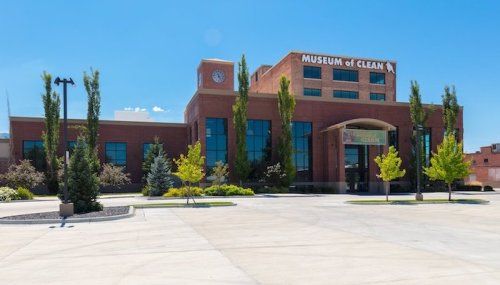 Exterior view of the Museum of Clean, featuring a brick building with trees and a clear blue sky.