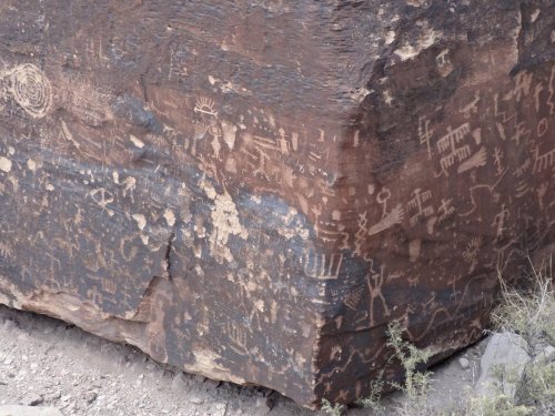 Petroglyphs etched into a large rock surface, showcasing various ancient symbols and designs.