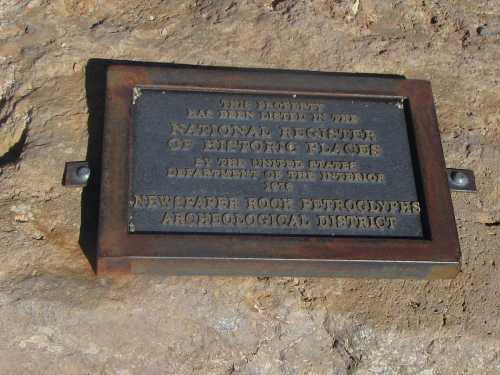 Plaque indicating the Newspaper Rock Petroglyphs Archaeological District is listed on the National Register of Historic Places.