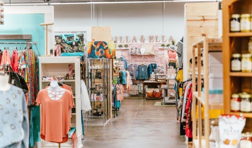 A vibrant retail store aisle showcasing colorful clothing and accessories, with displays on either side.