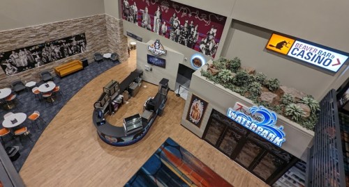 A spacious indoor area featuring a casino, waterpark entrance, seating, and decorative wall art.