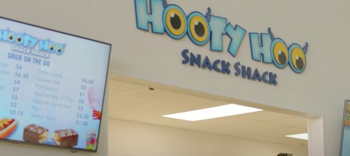 Sign for "Hooty Hoo Snack Shack" with a menu display featuring snack options.