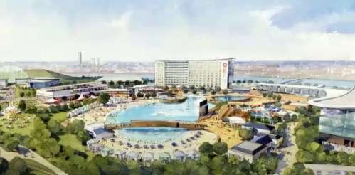 Aerial view of a large resort with a water park, beach area, and hotel, surrounded by greenery and city skyline.