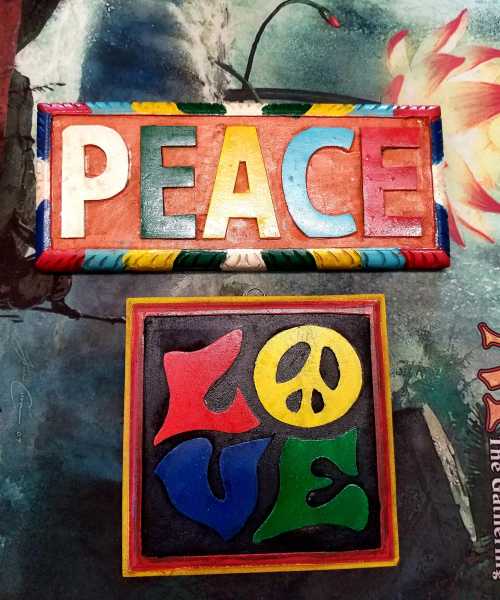 Colorful wooden signs displaying the words "PEACE" and "LOVE" in bold, vibrant letters.