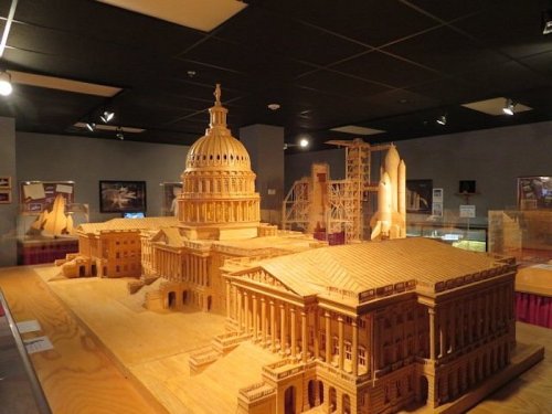 A detailed model of a government building made from wooden sticks, showcasing intricate architectural features.