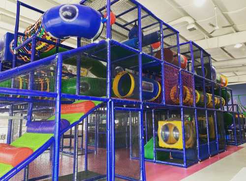 Colorful indoor play structure with slides and tunnels, designed for children's play and exploration.