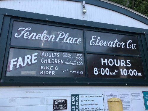 Sign for Fenelon Place Elevator Co. displaying fare prices and hours of operation. Open daily from 8:00 AM to 10:00 PM.