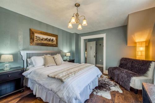 Cozy bedroom with a large bed, soft lighting, and rustic decor, featuring a cowhide rug and a plush seating area.