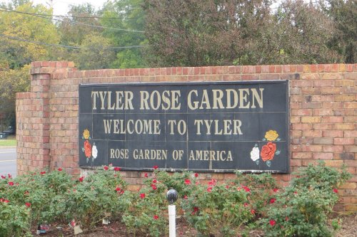 Sign for Tyler Rose Garden, welcoming visitors to Tyler, Texas, with roses depicted on the sign.
