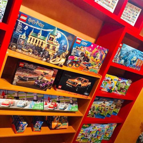 A colorful shelf displaying various LEGO sets, including Harry Potter, City, and Speed themes.