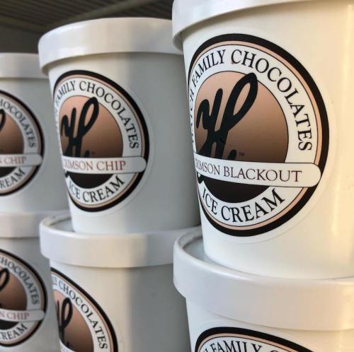 Containers of ice cream labeled "Crimson Chip" from "HP Family Chocolates," stacked together.