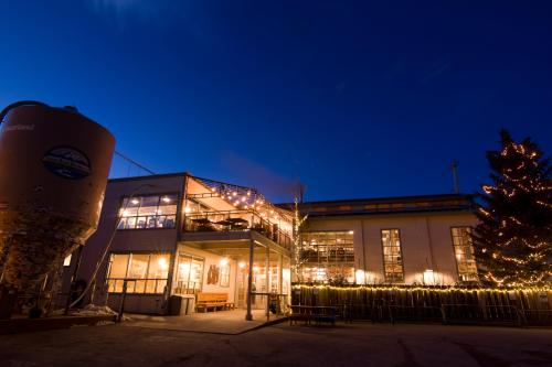 A cozy building with string lights and a decorated tree, set against a twilight sky.