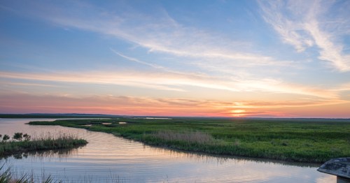 Colorful coastal sunrise as seen from Cypremort Point State Park in Louisiana over the bay