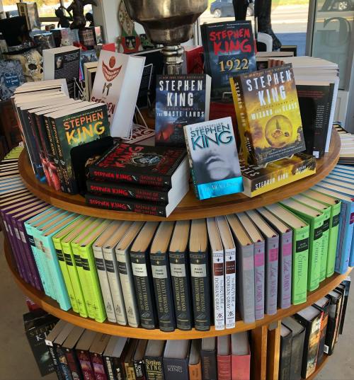 A circular display of books featuring various titles by Stephen King, surrounded by colorful book spines.