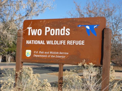 Sign for Two Ponds National Wildlife Refuge, featuring a blue bird graphic and information about the U.S. Fish and Wildlife Service.