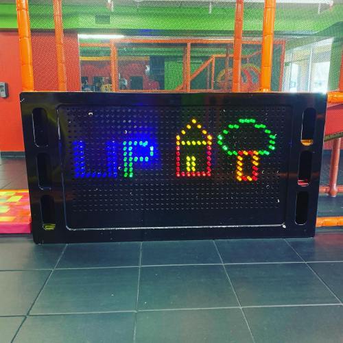 Colorful LED display showing the words "LIP" and images of a house and tree in a play area.
