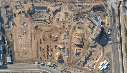 Aerial view of a large construction site with various machinery and earth-moving activities.
