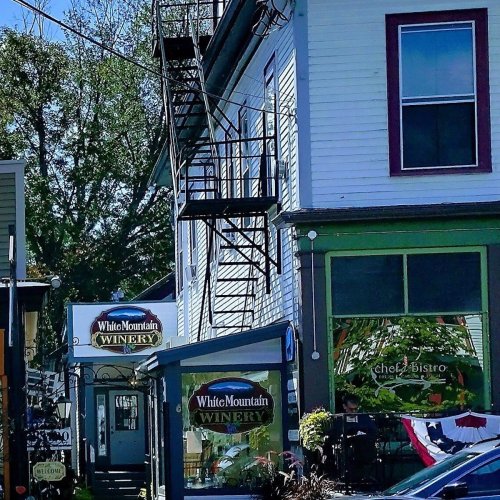 A charming winery building with a bistro, featuring a fire escape and colorful signage on a sunny day.