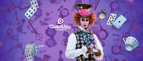 A whimsical character in colorful attire stands against a purple background filled with keys, playing cards, and clocks.