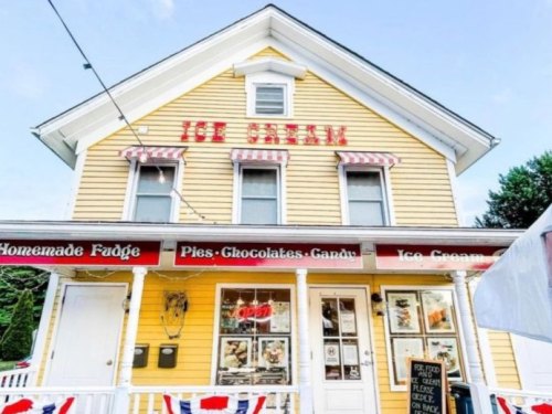 A charming yellow ice cream shop with red signage, featuring homemade fudge, pies, and candy.