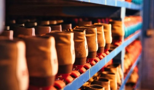 A close-up of a shelf lined with various pairs of roller skates in a colorful array.