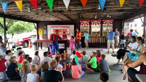 A lively carnival scene with children watching a performance under a decorated pavilion, surrounded by colorful banners.