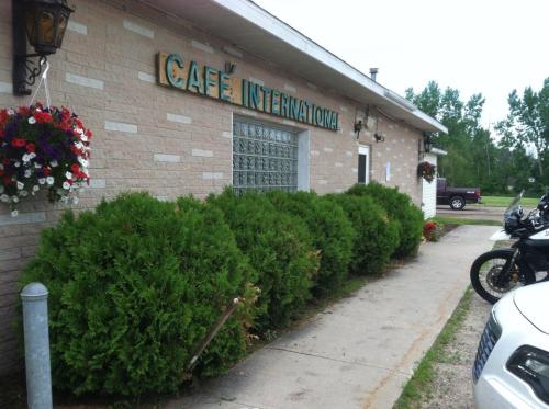 Exterior of Café International, featuring a brick building, greenery, and hanging flower baskets.