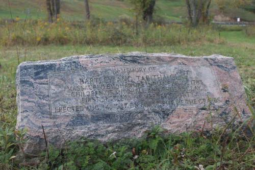 A stone memorial marker commemorating Bartley and Tabitha Clay, victims of a massacre in 1783, located in a grassy area.