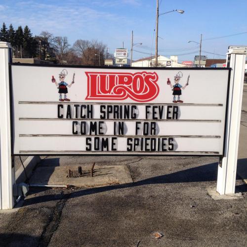 Sign for Lupo's reads: "Catch spring fever! Come in for some spiedies." Bright day with clear skies in the background.
