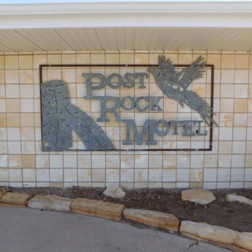 Sign for "Lost Rock Motel" featuring a stylized rock and bird design on a stone wall.