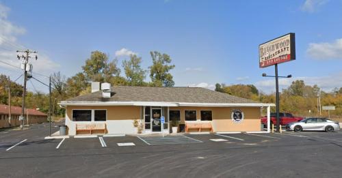 A single-story building with a sign reading "Briarwood Realty," surrounded by trees and a parking lot.