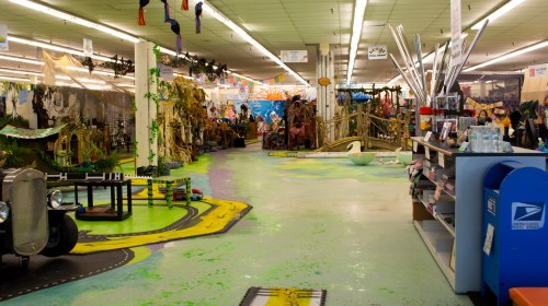 A colorful, whimsical store interior filled with decorations, props, and a vibrant floor design.