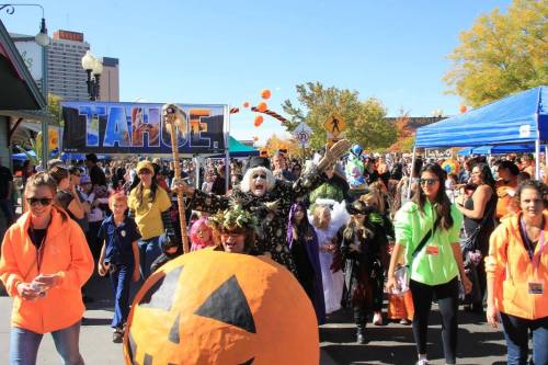 A lively Halloween parade in Tahoe with costumed participants, colorful decorations, and festive atmosphere.