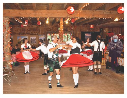 A lively dance scene with couples in traditional attire twirling in a decorated hall, festive lights and decorations around.